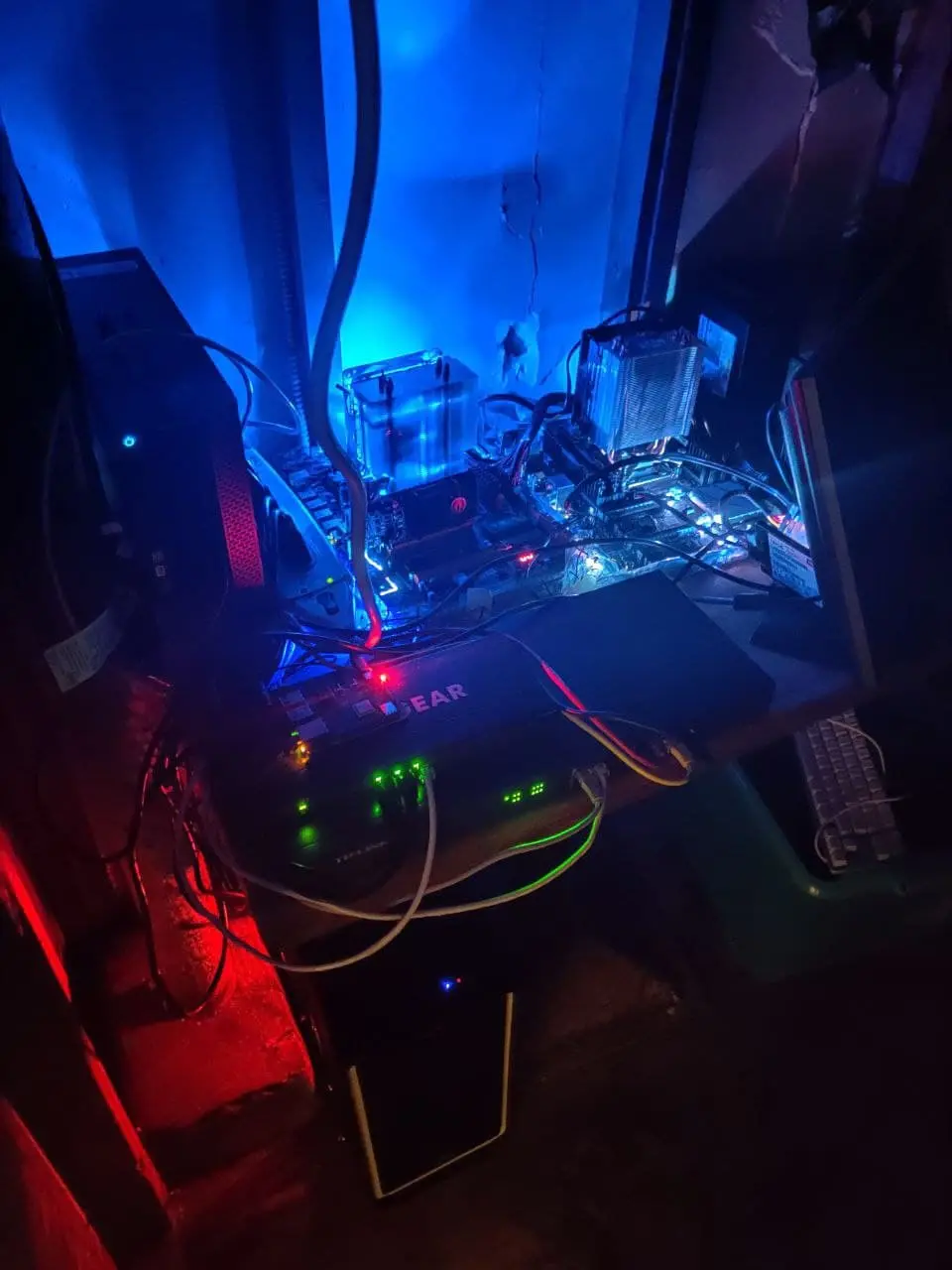 Picture of several server computers glowing blue in the dark.